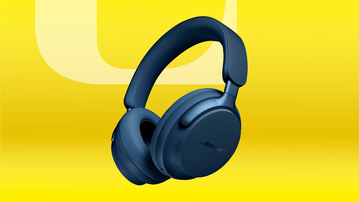 A pair of blue headphones against a yellow gradient CNET background.