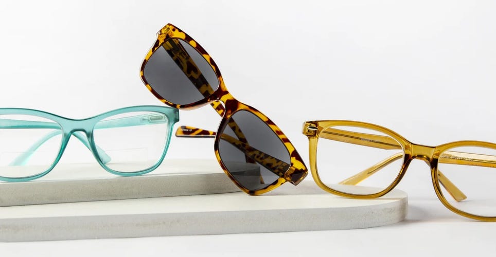 Glasses and sunglasses on a white surface.