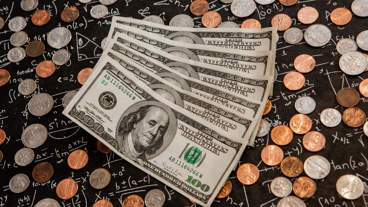 six one-hundred dollar bills surrounded by coins