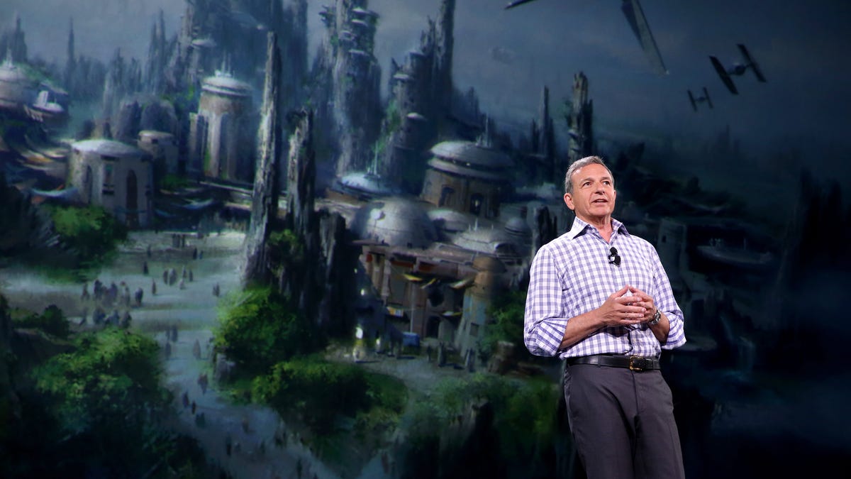 Bog Iger stands in front of a dramatic Star Wars city illustration.