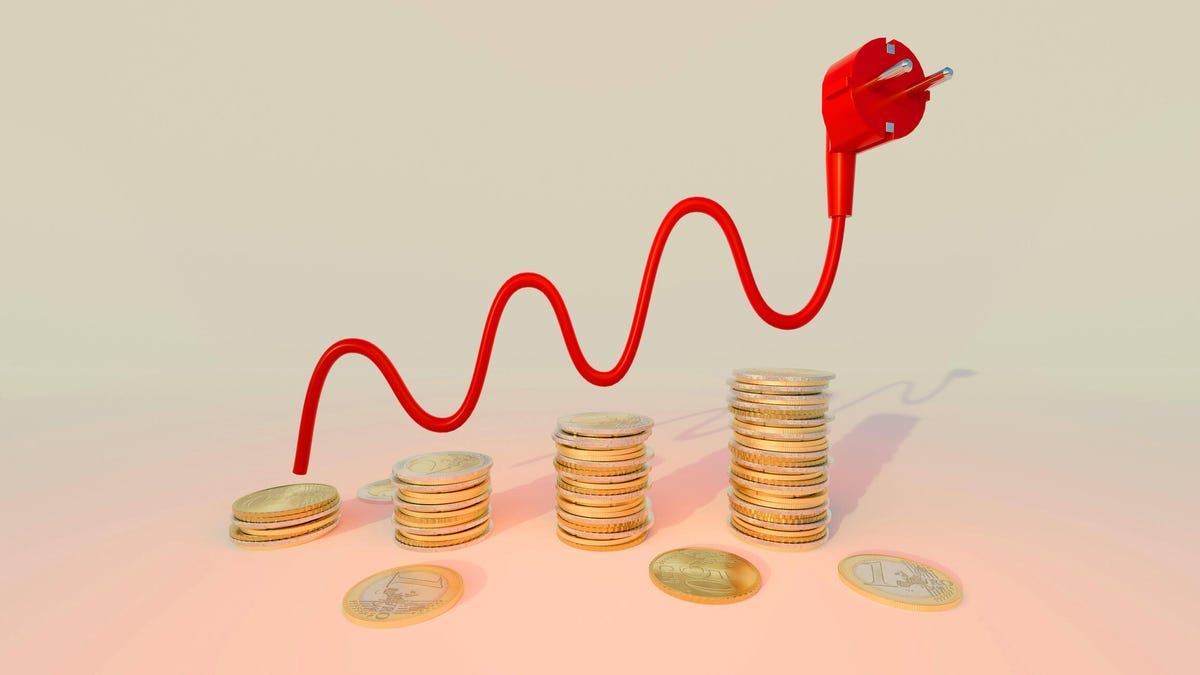 An electrical cord acts as a line graph over stacks of coins.