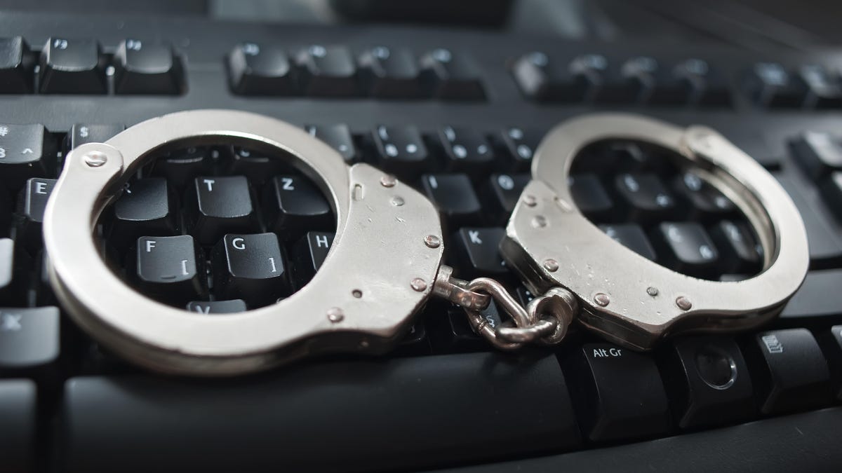 Close-Up Of Handcuffs On Computer Keyboard