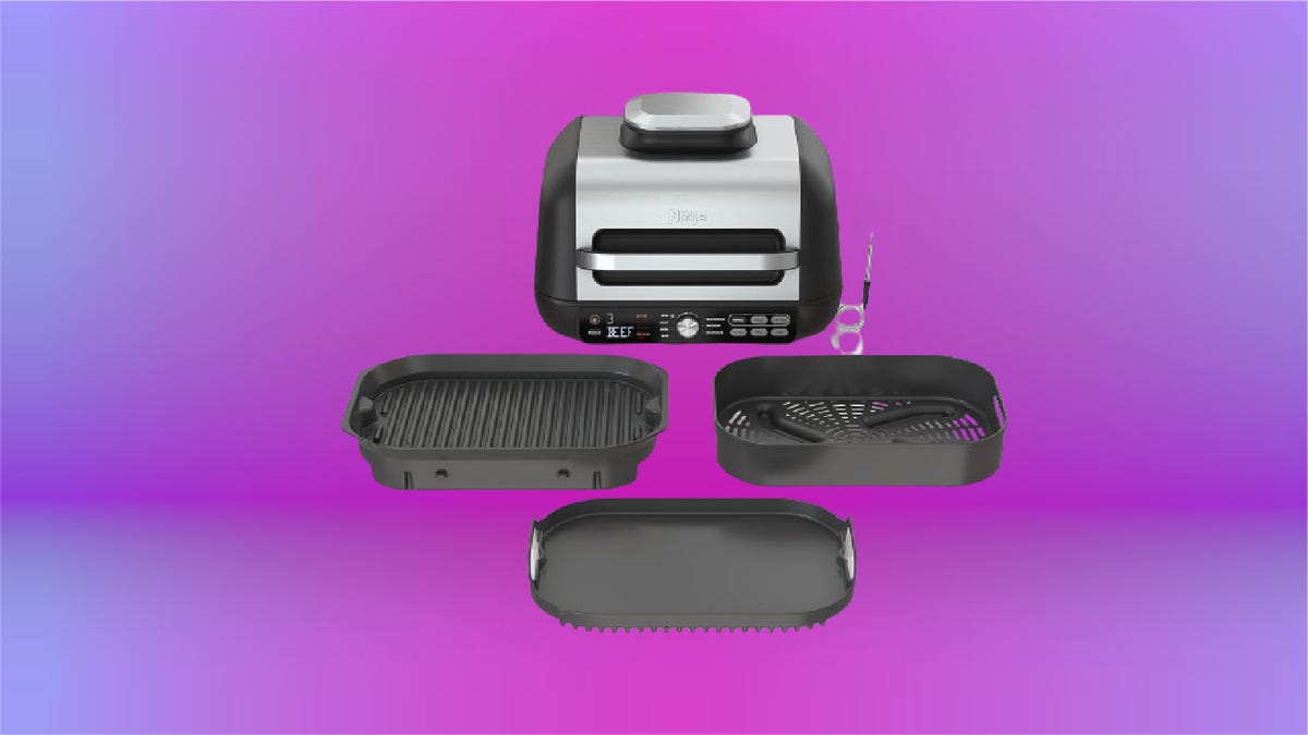 black indoor grill with four burgers on the burner against lavender background