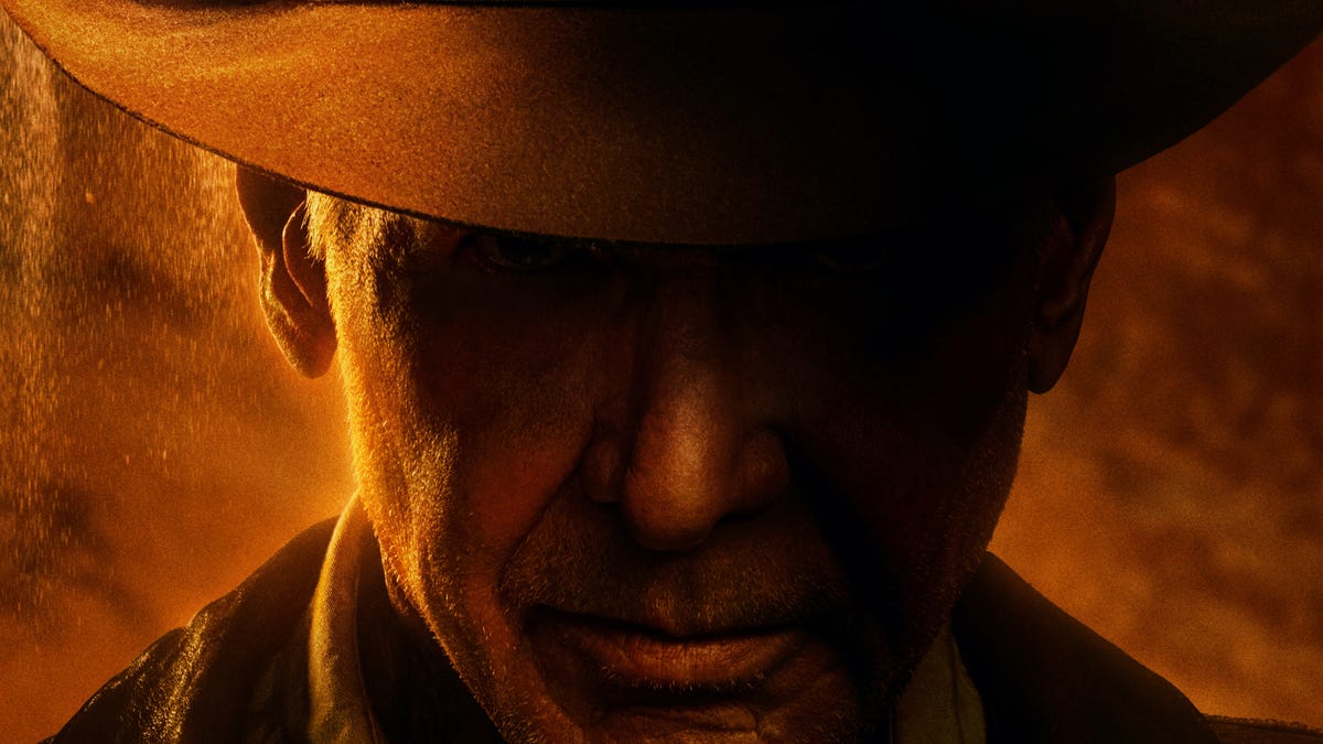Indiana Jones is seen in shadow, with light hitting the right side of his face.