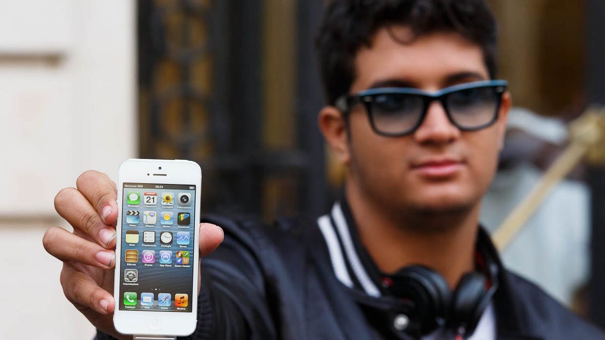 Anthony Fitch holds the first iPhone 5sold at Apple's store near Paris' Opera house. He waited in line about 40 hours to get the phone.