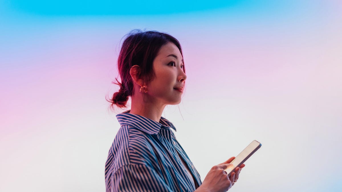 A photo of a woman holding a smartphone gettyimages-1962728132
