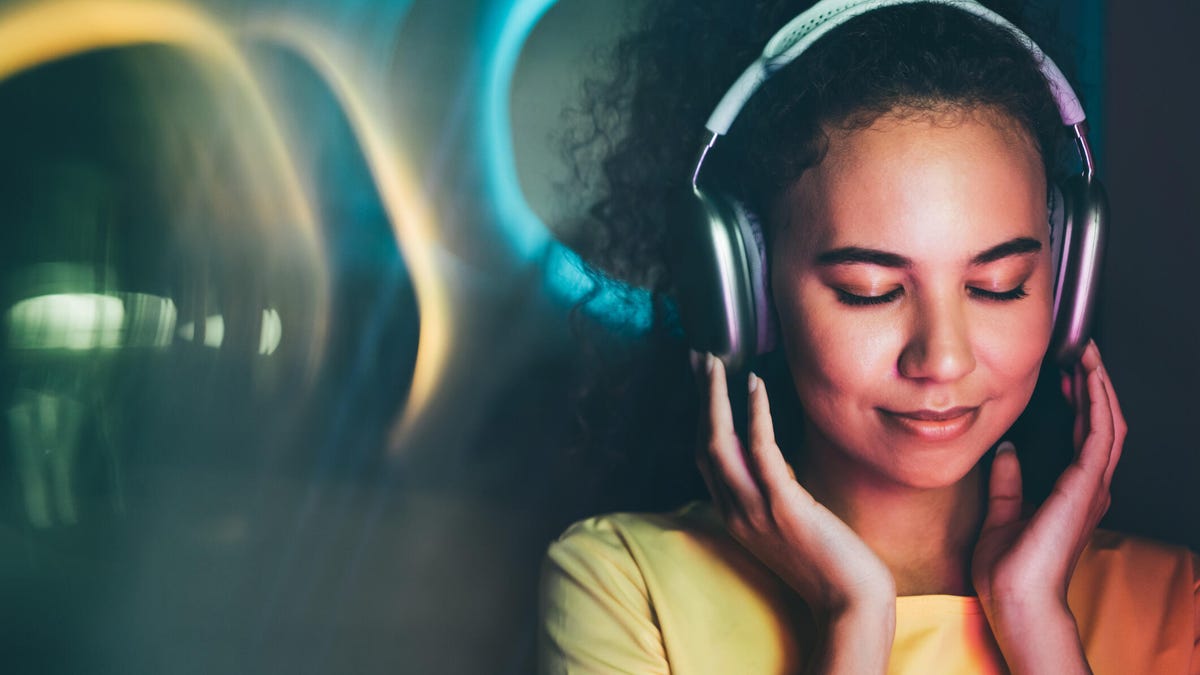A woman with eyes closed, wearing headphones