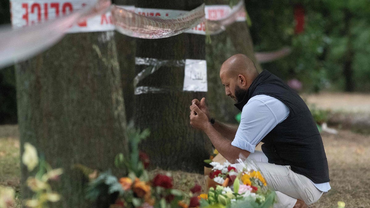 A man sits outside the Masjid Al Noor mosque in Christchurch, New Zealand, following the mass shooting.
