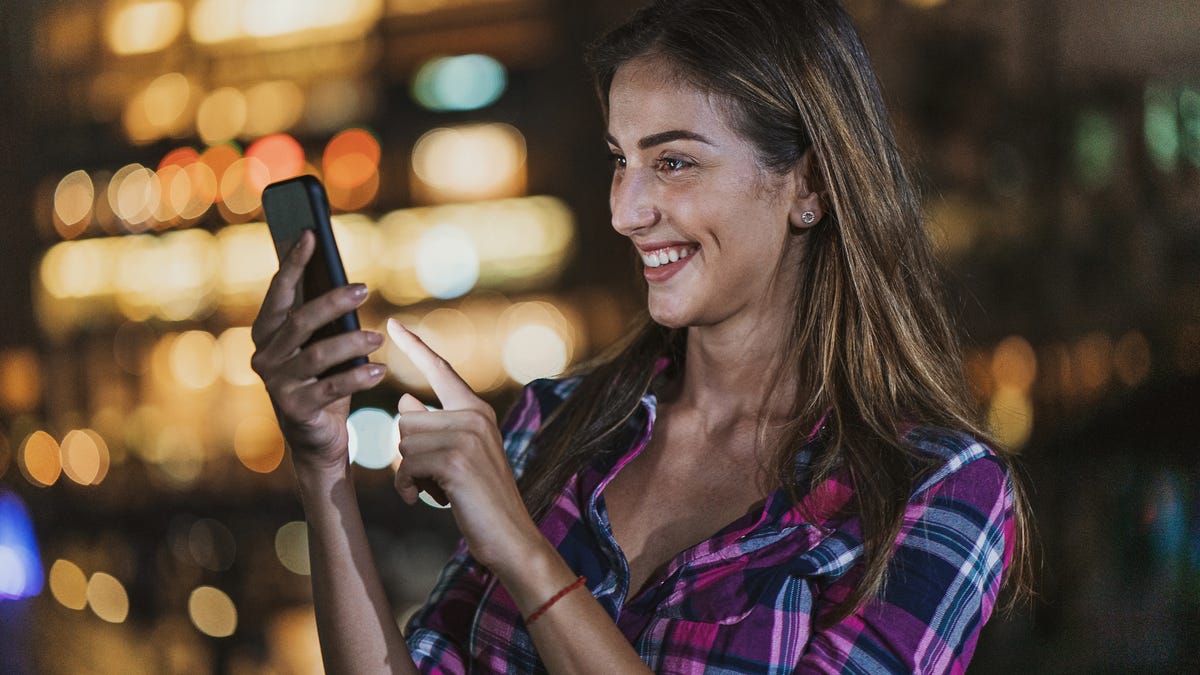 Young woman uses an app at night.