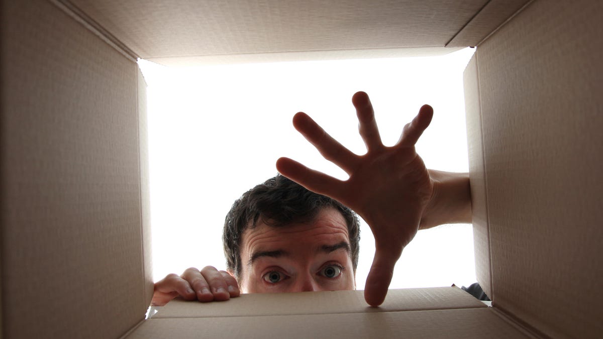 A man reaches a hand into a a box.