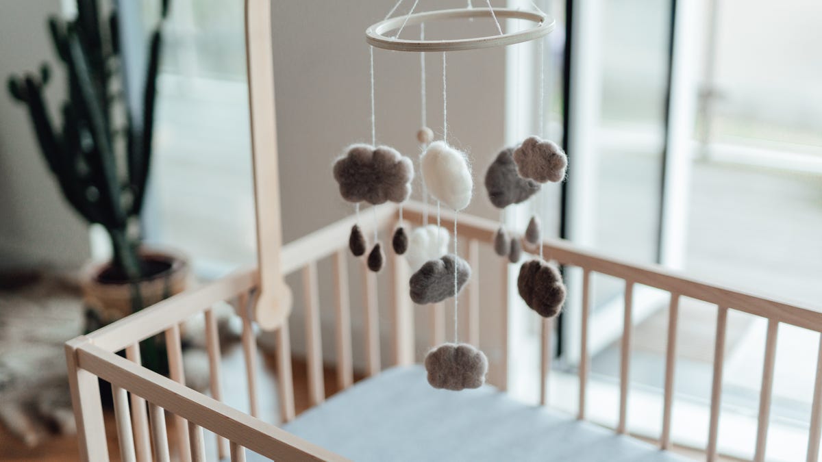 A mobile hangs over a crib