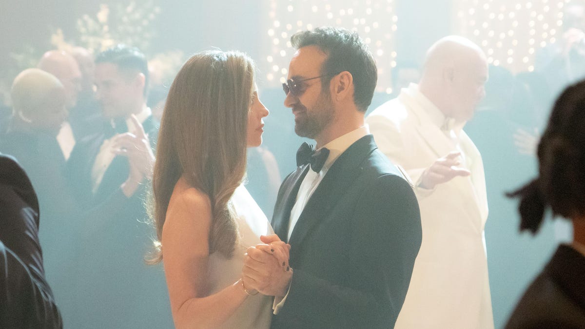 man in tux dances with woman in formal attire