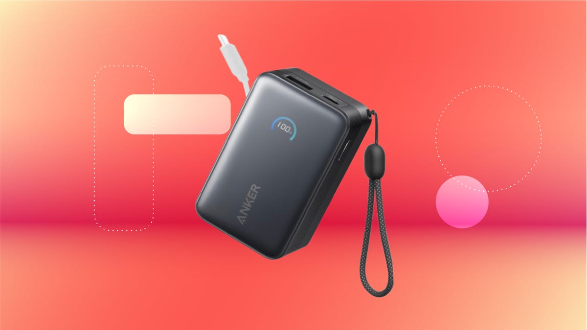 Rectangular Anker power bank with retractable cable against red orange CNET background.