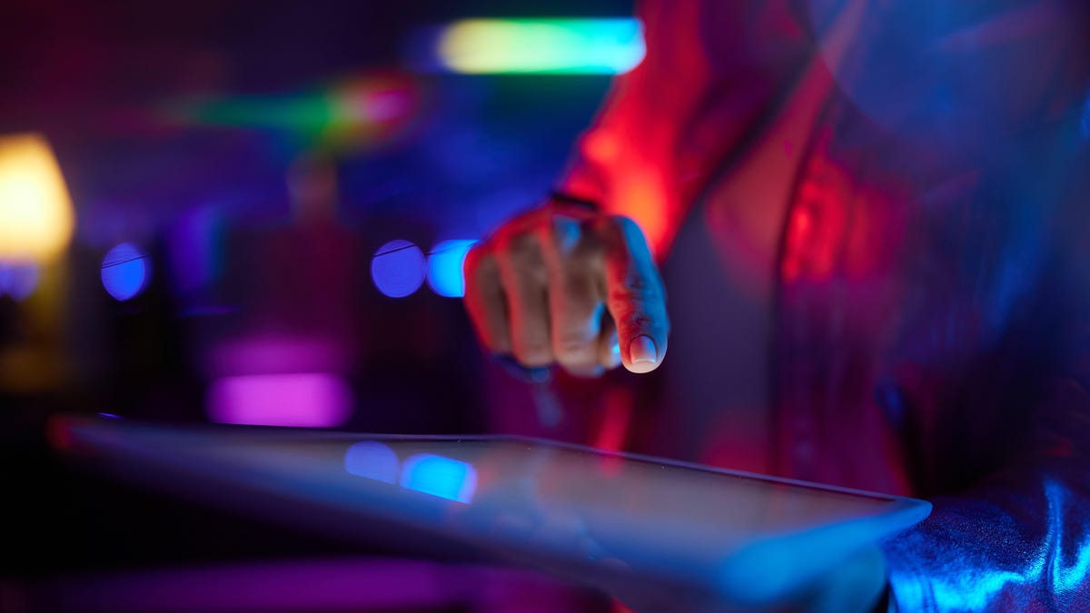 A hand pushes a button on a tablet