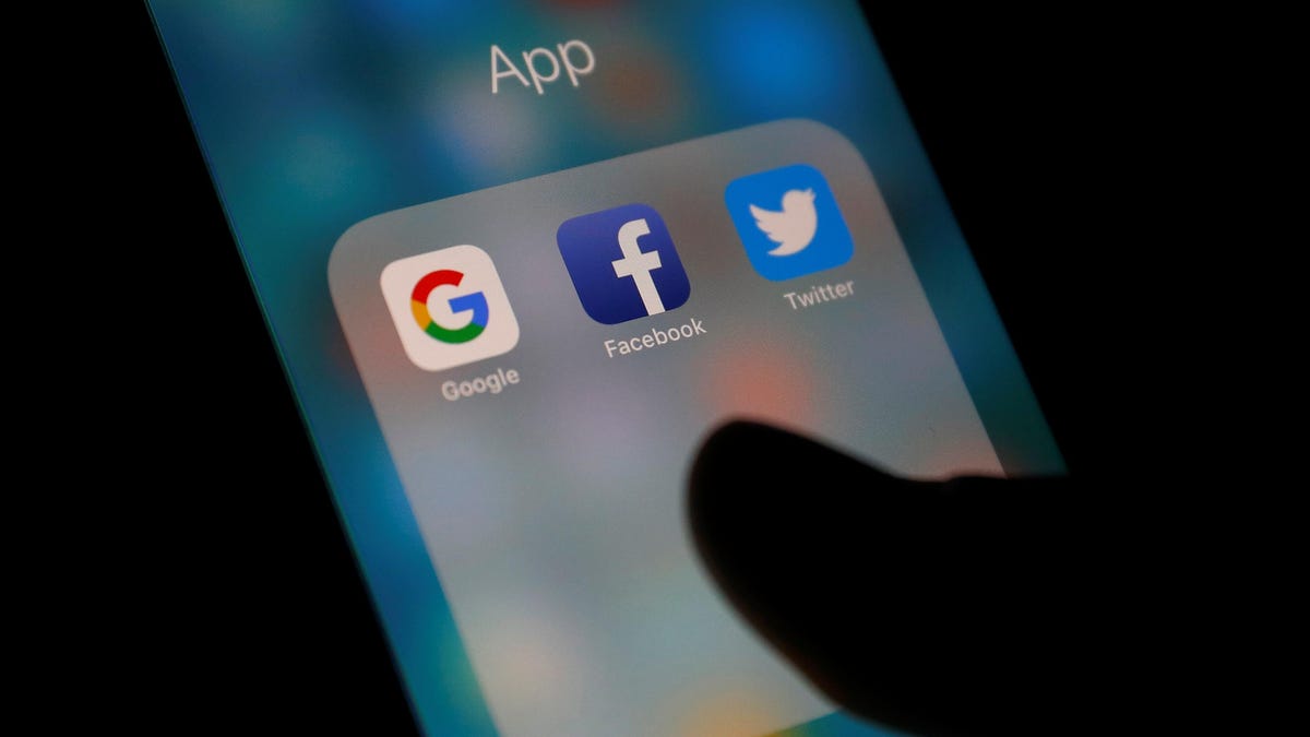 Google, Facebook and Twitter logos on a phone screen