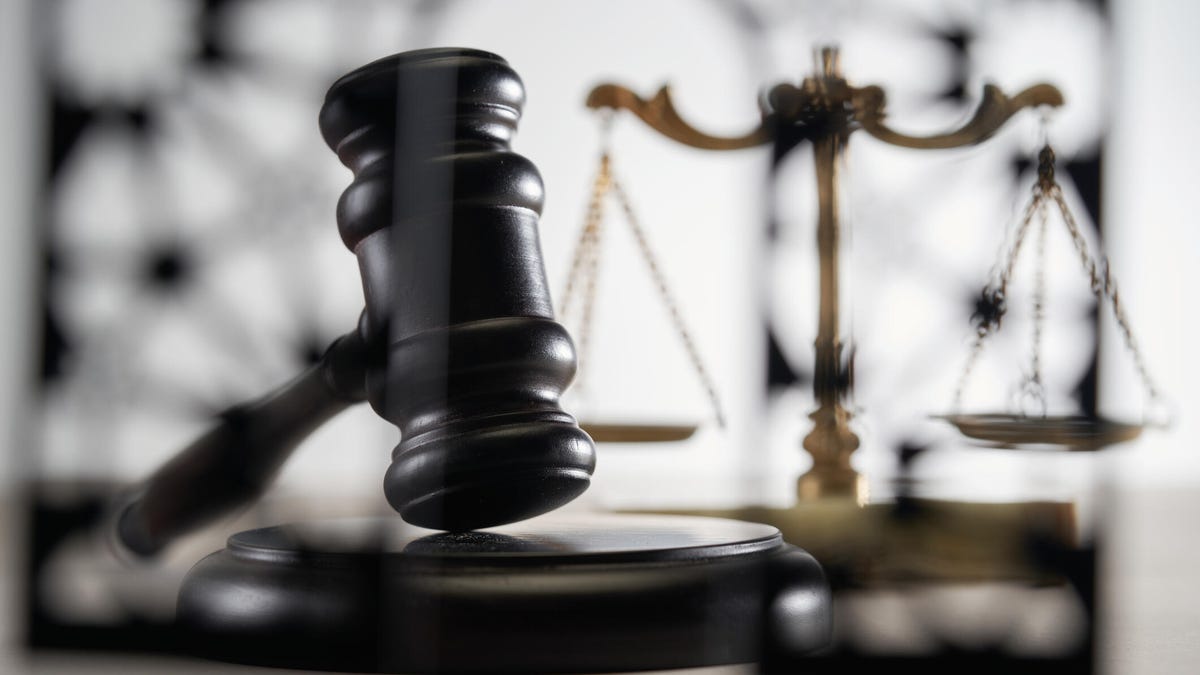 A gavel in the foreground and scales in the background