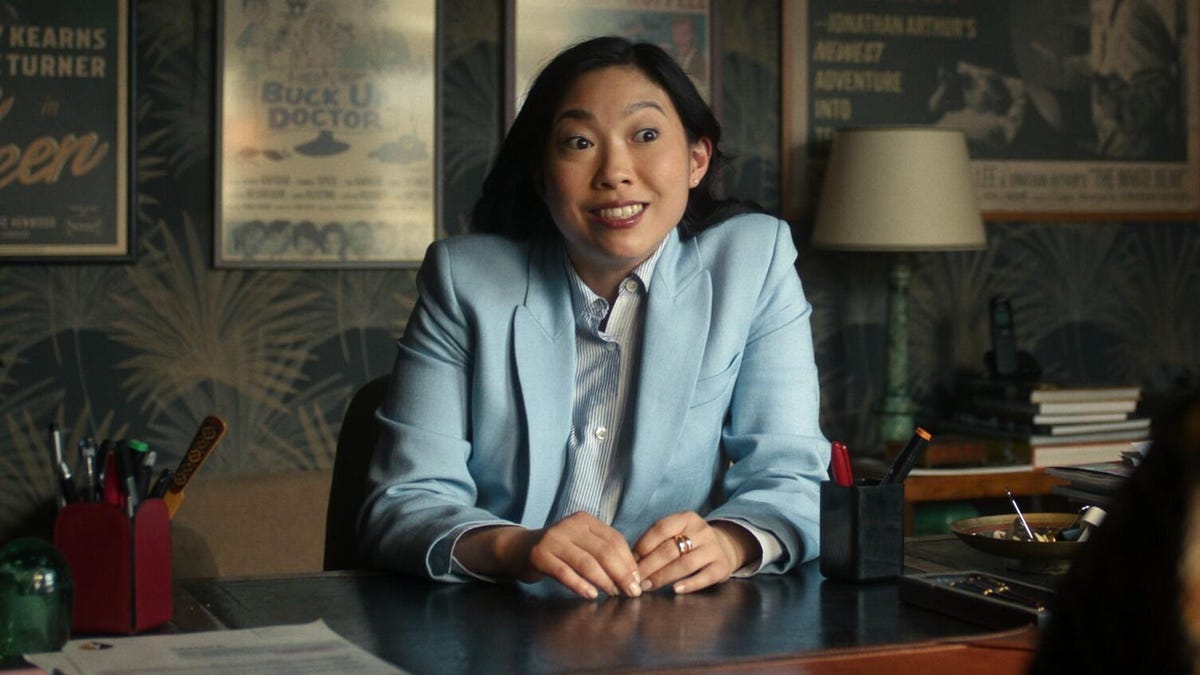 Woman in blue jacket at desk smiling