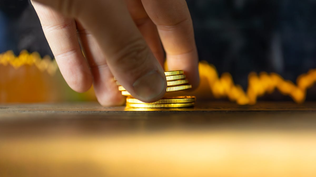 A hand setting coins on the table