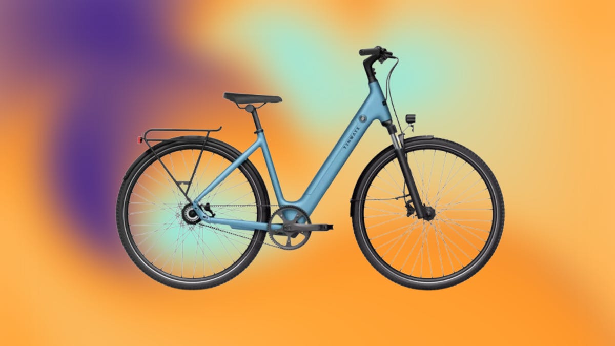 Light blue e-bike with black wheels against orange and purple gradient background.