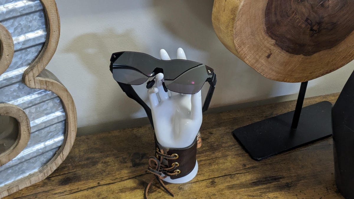 A pair of Rayneo XR glasses on a white mannequin hand