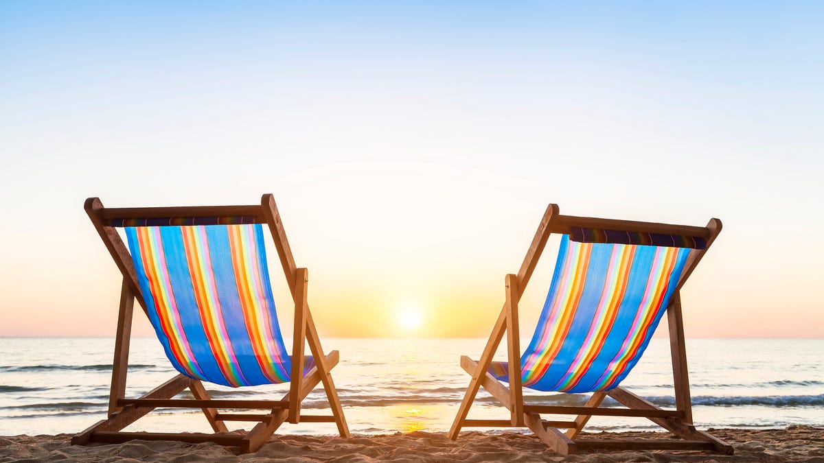 two beach chairs facing the water