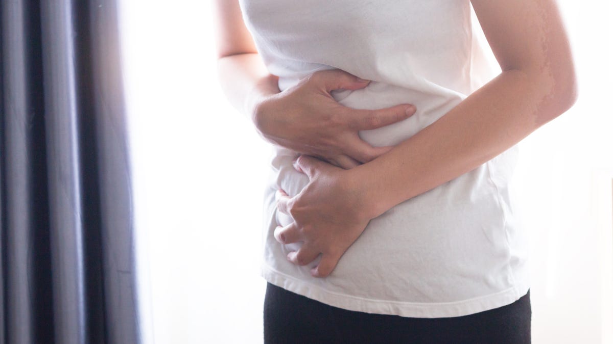 A woman clutching her abdomen in pain.
