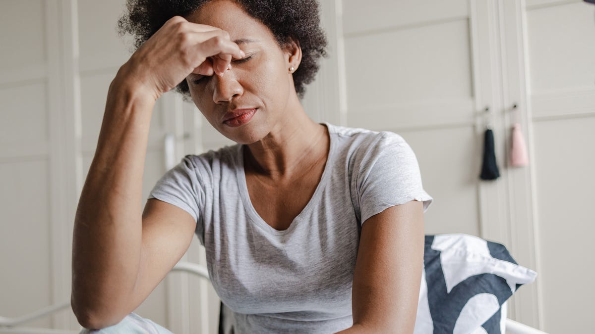 Woman holding the bridge of her nose while feeling stressed