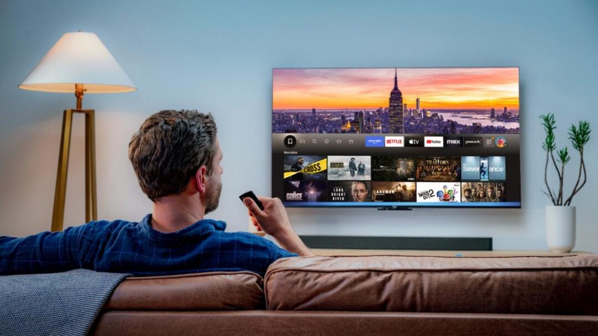 man watching prime video on TV that's mounted on a wall