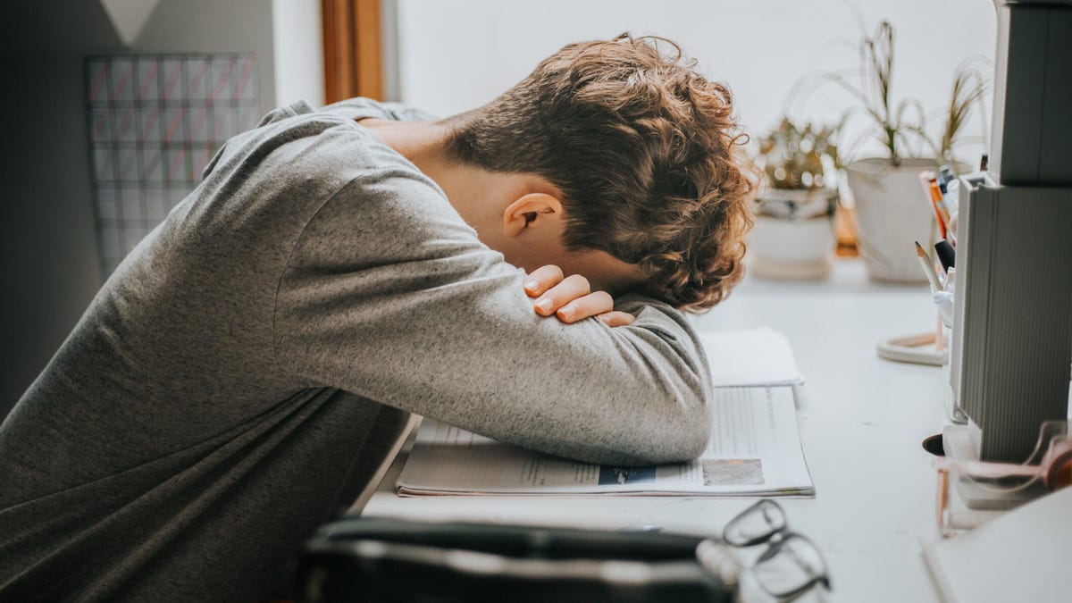Tired college student resting on his books.