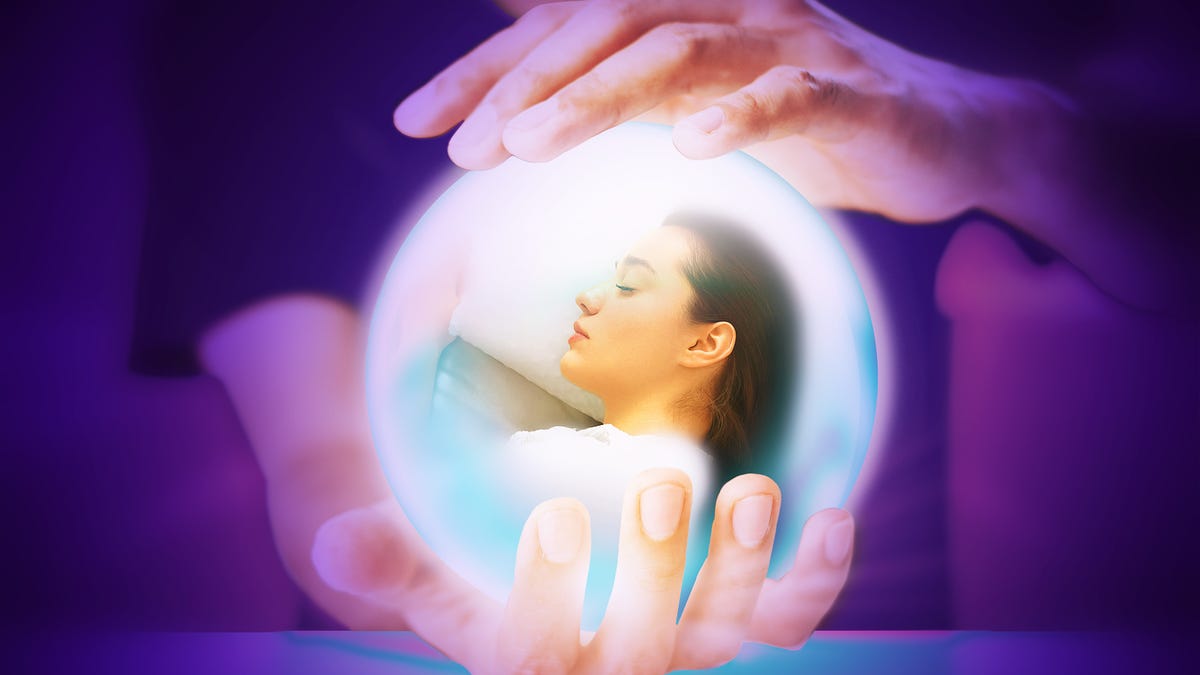 Person holding a crystal ball with a person sleeping inside.
