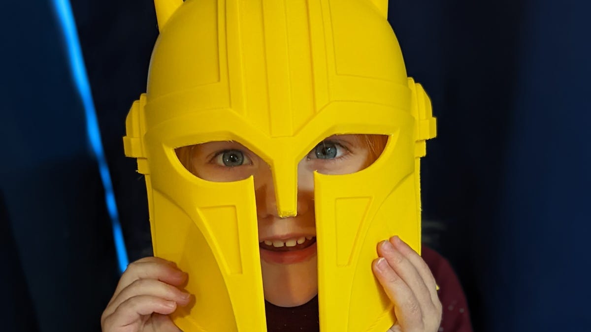 Small child wearing a helmet from the Mandalorian