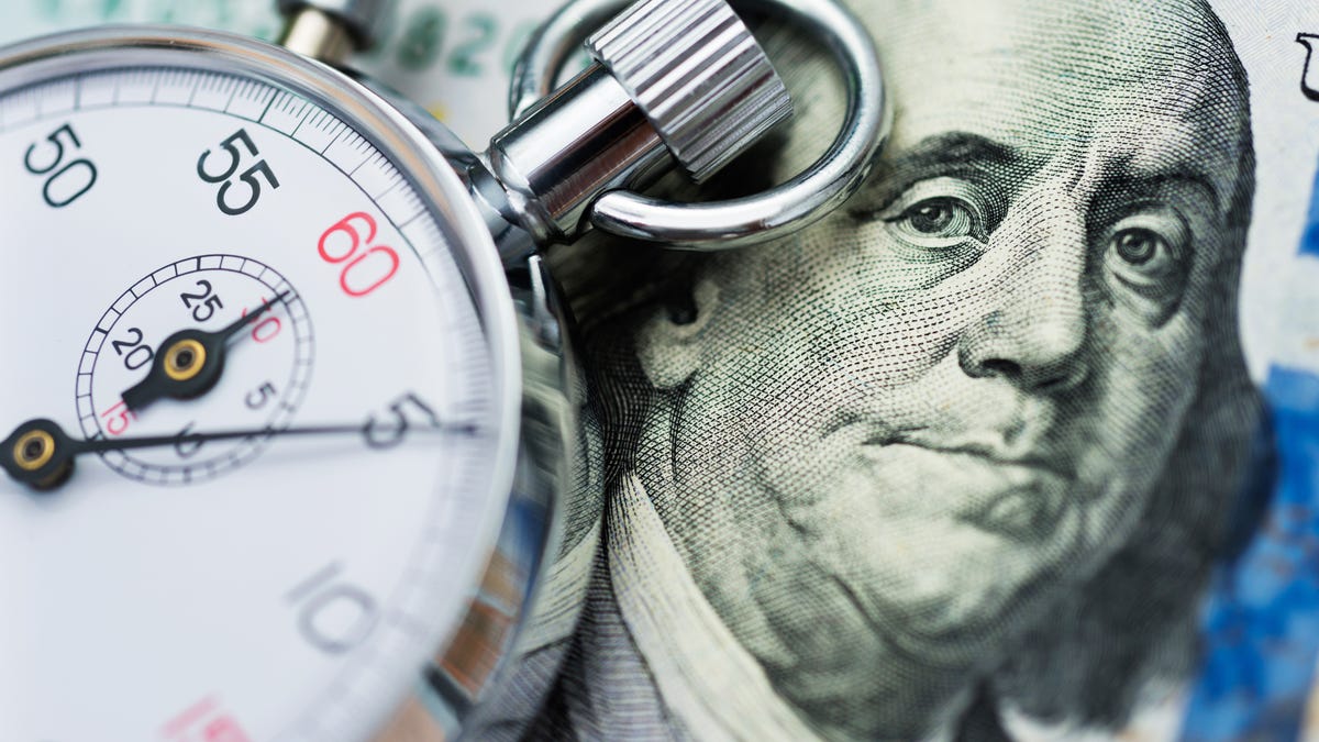 A stopwatch on top of a $100 bill