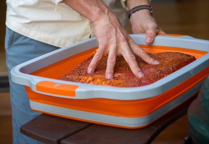 person seasoning meat in prep dub