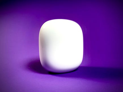 A single, snow-colored Nest Wifi Pro mesh router sitting against a purple background.