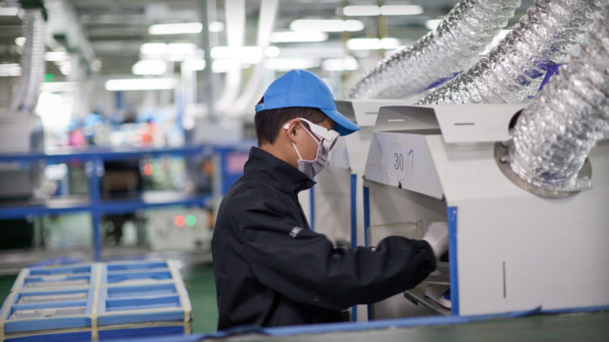 A worker at an Apple supplier facility in Chengdu, China, uses a laser etching machine.