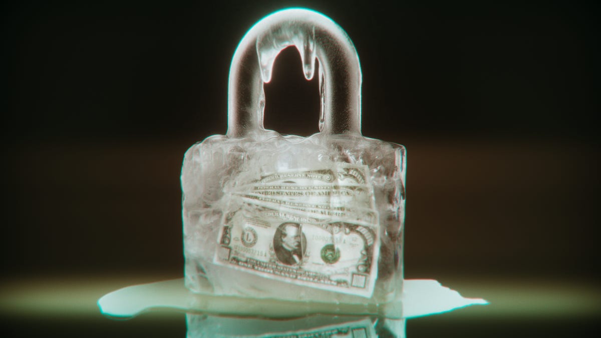 A padlock made out of ice with 100 dollar bills frozen within