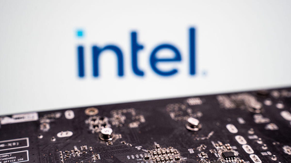 A semiconductor chipset sits in the foreground of the image while an Intel logo is in the back.