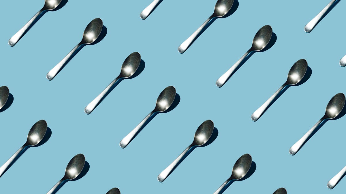 Diagonal pattern of spoons on a blue background