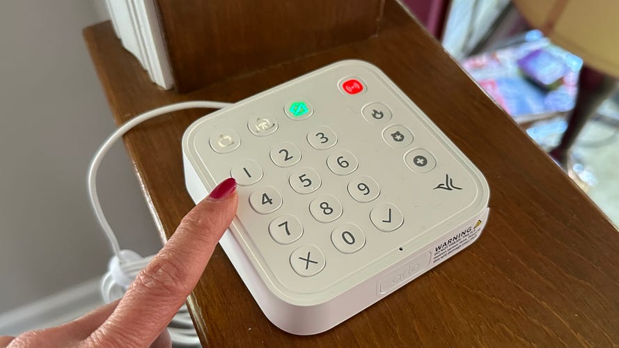 arlo-home-security-system-finger-on-button
