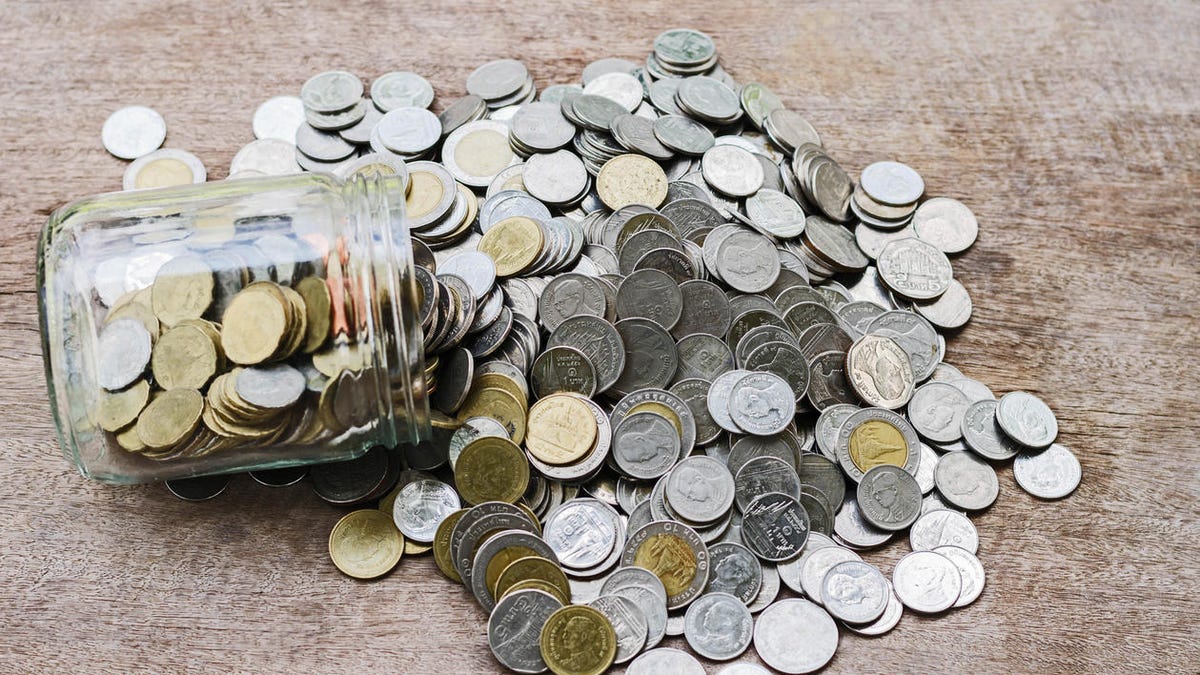 Coins in glass jar with investment financial concept and stack money on wood background