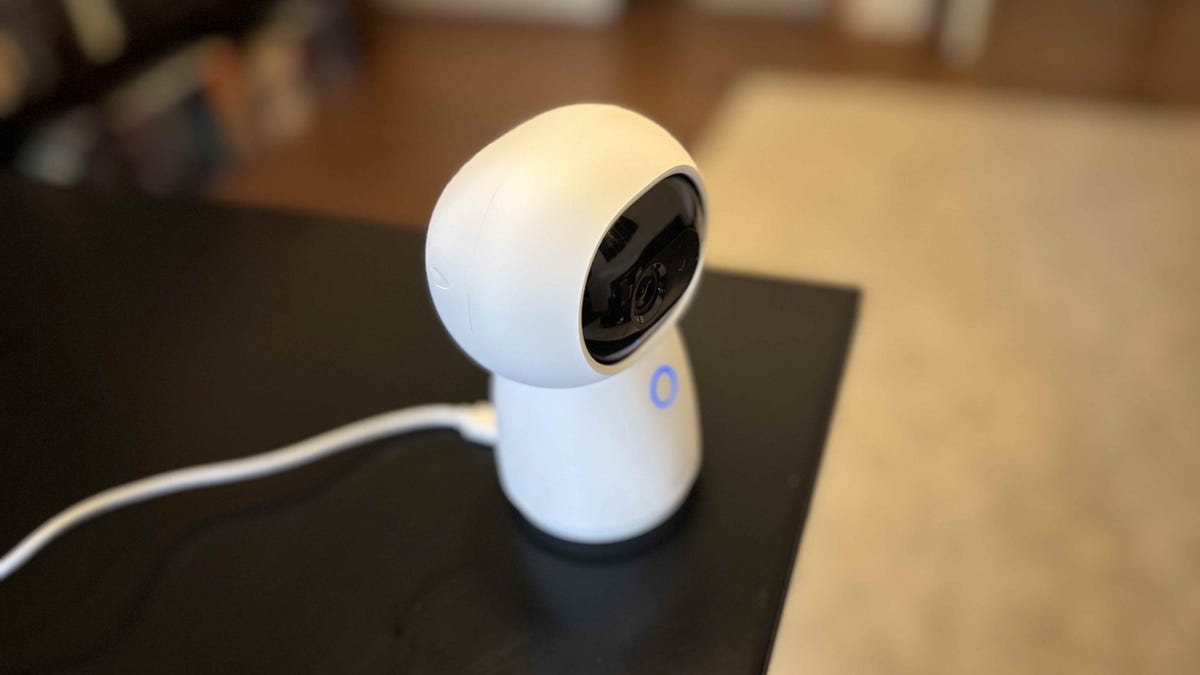 Aqara's G3 camera hub on a black desk.