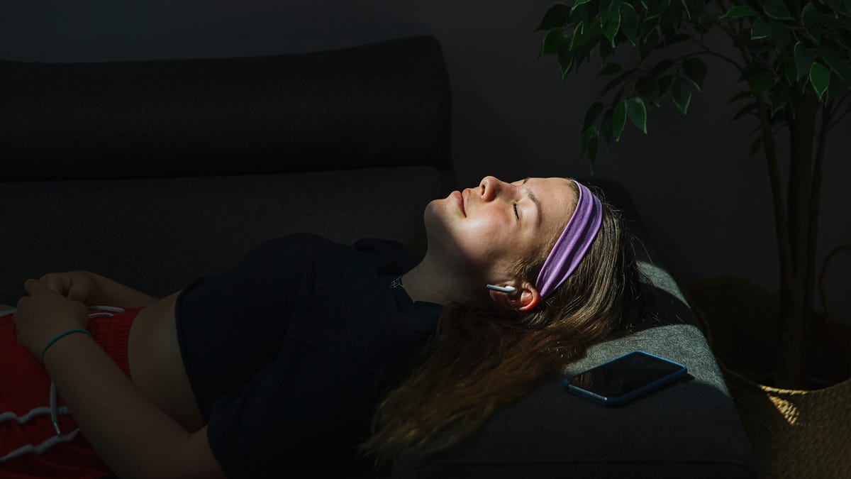 A girl listening to music with headphones as she falls asleep