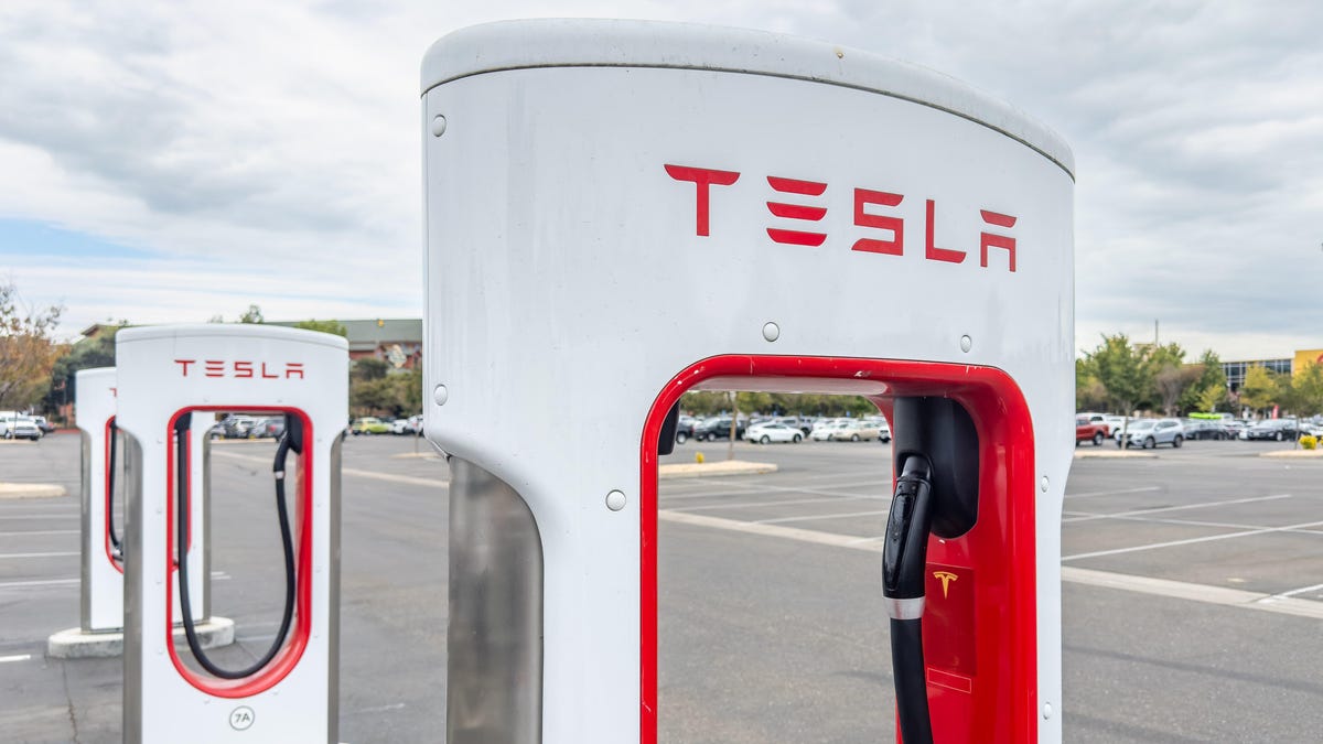 A red and white Tesla Supercharger for charging electric vehicles