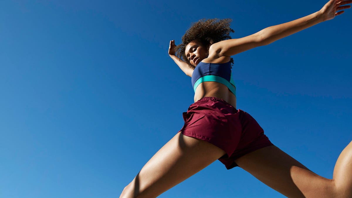 A woman leaping against a dark blue sky