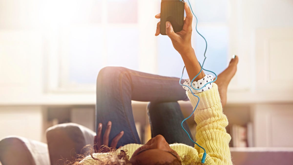 Woman relaxing at home listening to her phone.