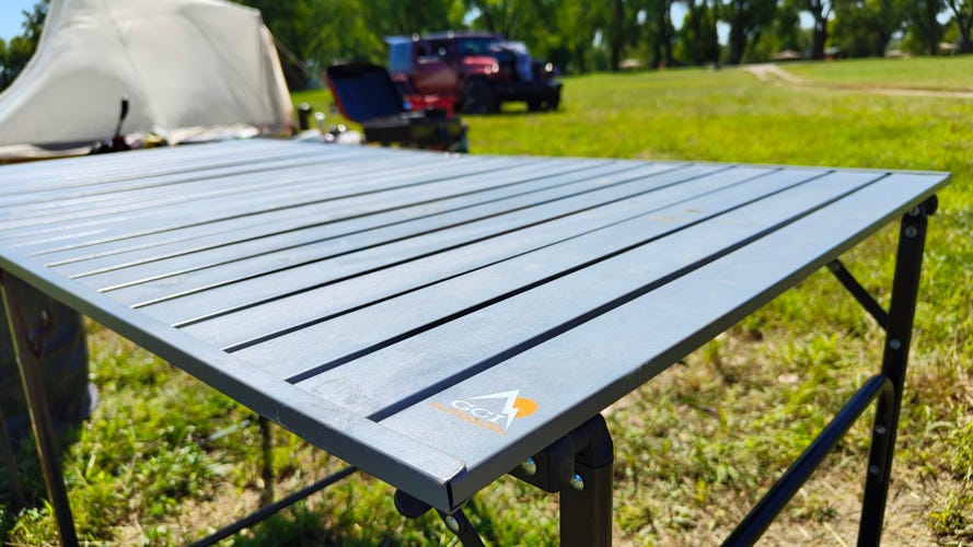 GCI Slim Fold Table outside at a campsite.