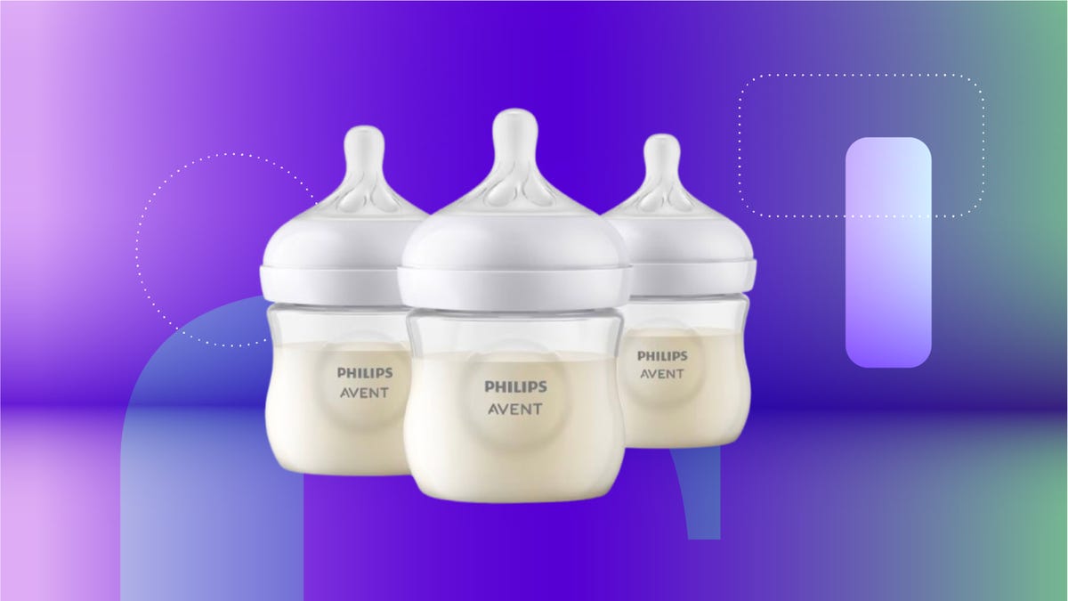 Transparent baby bottles with white top against purple and mint green CNET background.