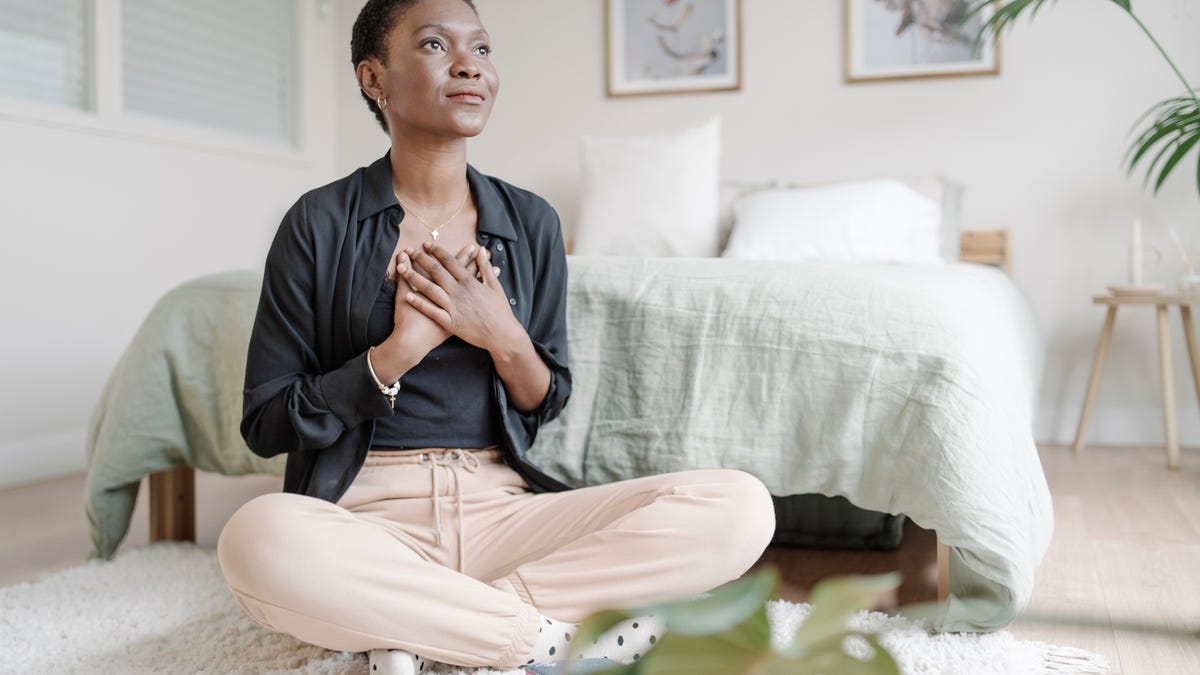 Woman with hands on chest expressing gratitude.