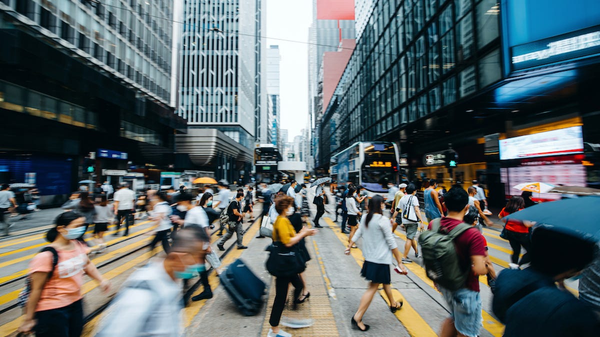 A crowd of people crossing a city street.