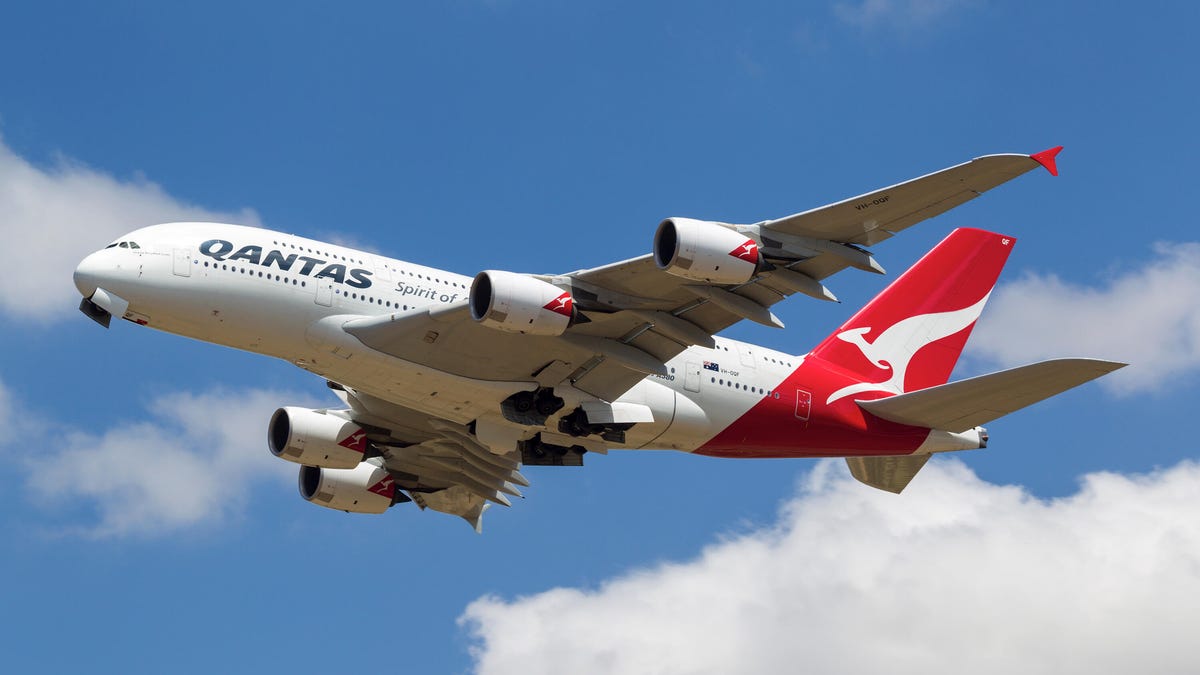 Qantas airplane in the sky on a sunny day.